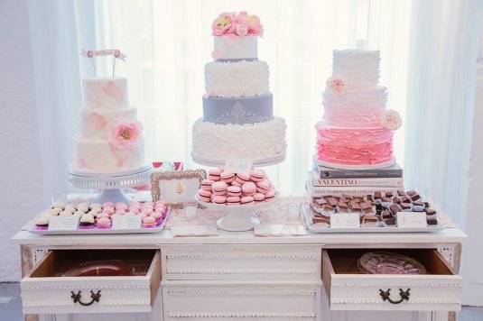 white purple and pink wedding cakes on white dresser
