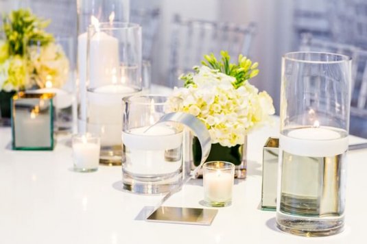 white modern table with glass vases and silver table number