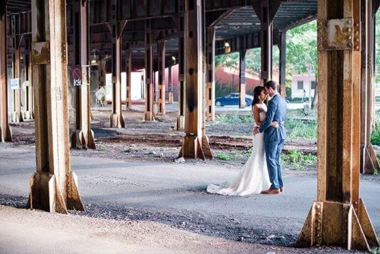 bride and groom artisitc photo underneath bridge