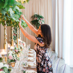 wedding planner placing flowers in centerpiece
