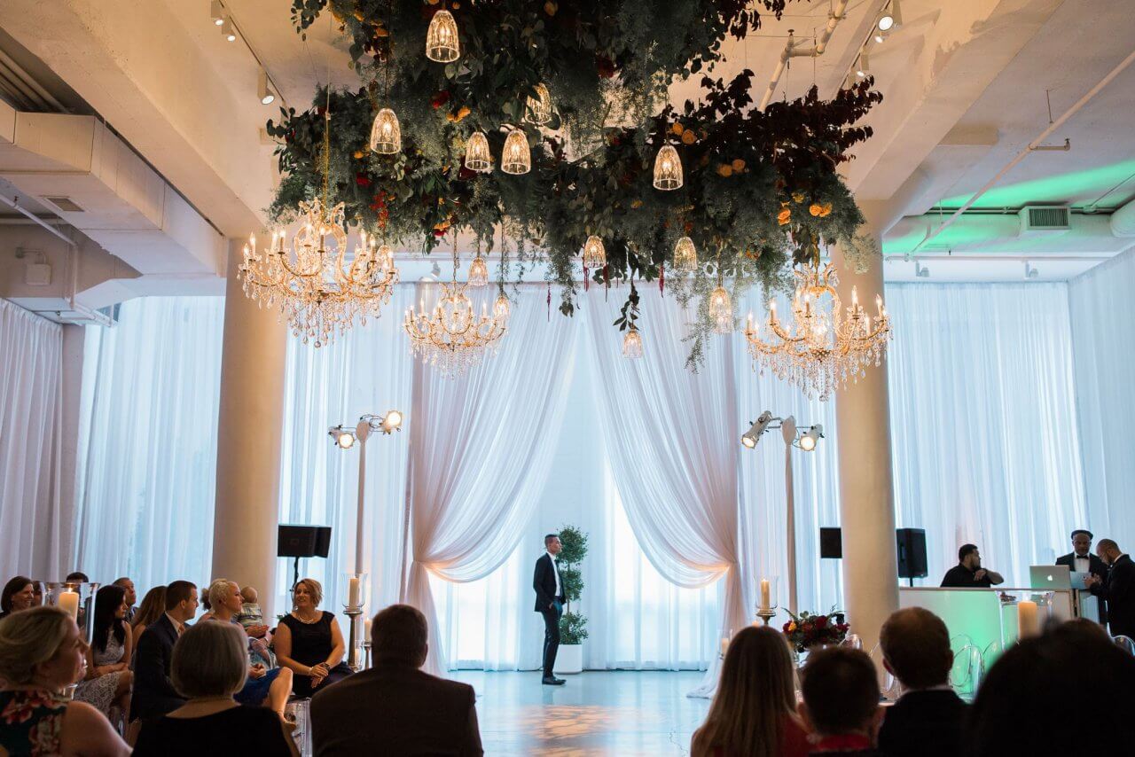 center ceremony with overhead greeney and golden chandeliers