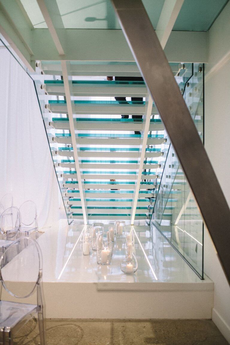 collection of candles underneath glass stsircase