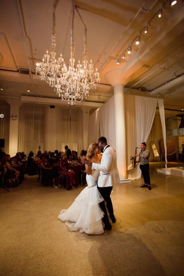 chicago bride and groom first dance beneath chandelier at chez wedding venue