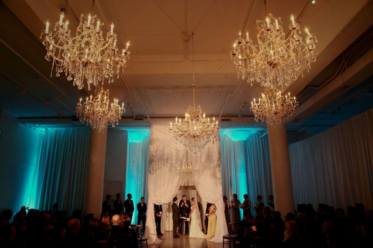 gold and blue wedding ceremony with white draped chuppah