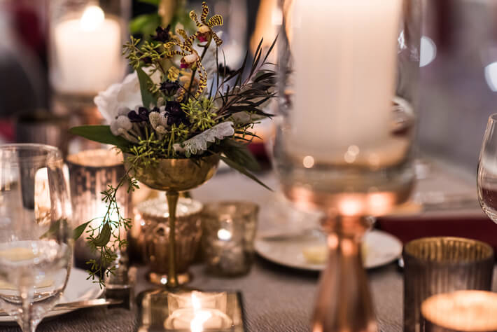gold votives and vases on wedding table