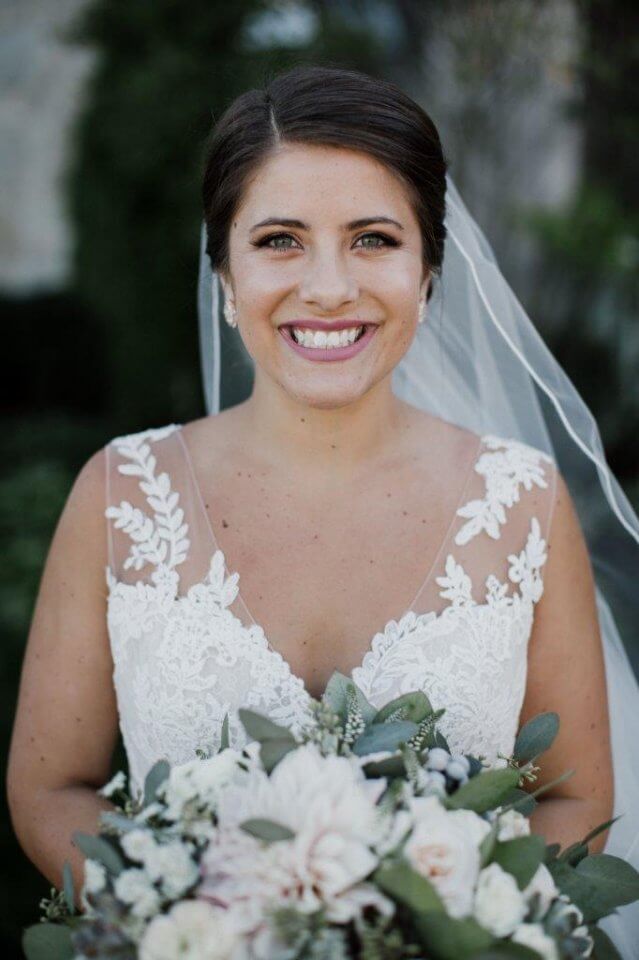 bride in lace wedding dress holds suculent bouquet