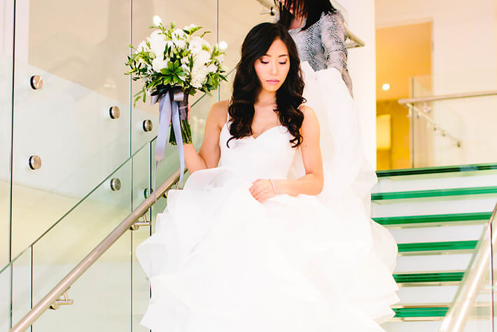 bride walks down glass staircase at chez wedding venue