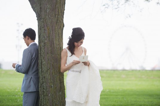 bride and groom read notes to each ohter in front of navy pier