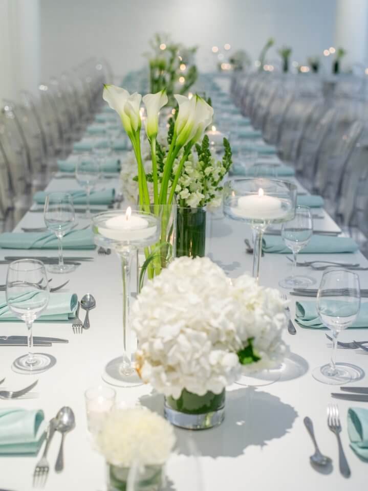 white table with teal napkins and green and white florals