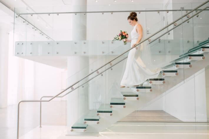 bride walks down chez glass staircase