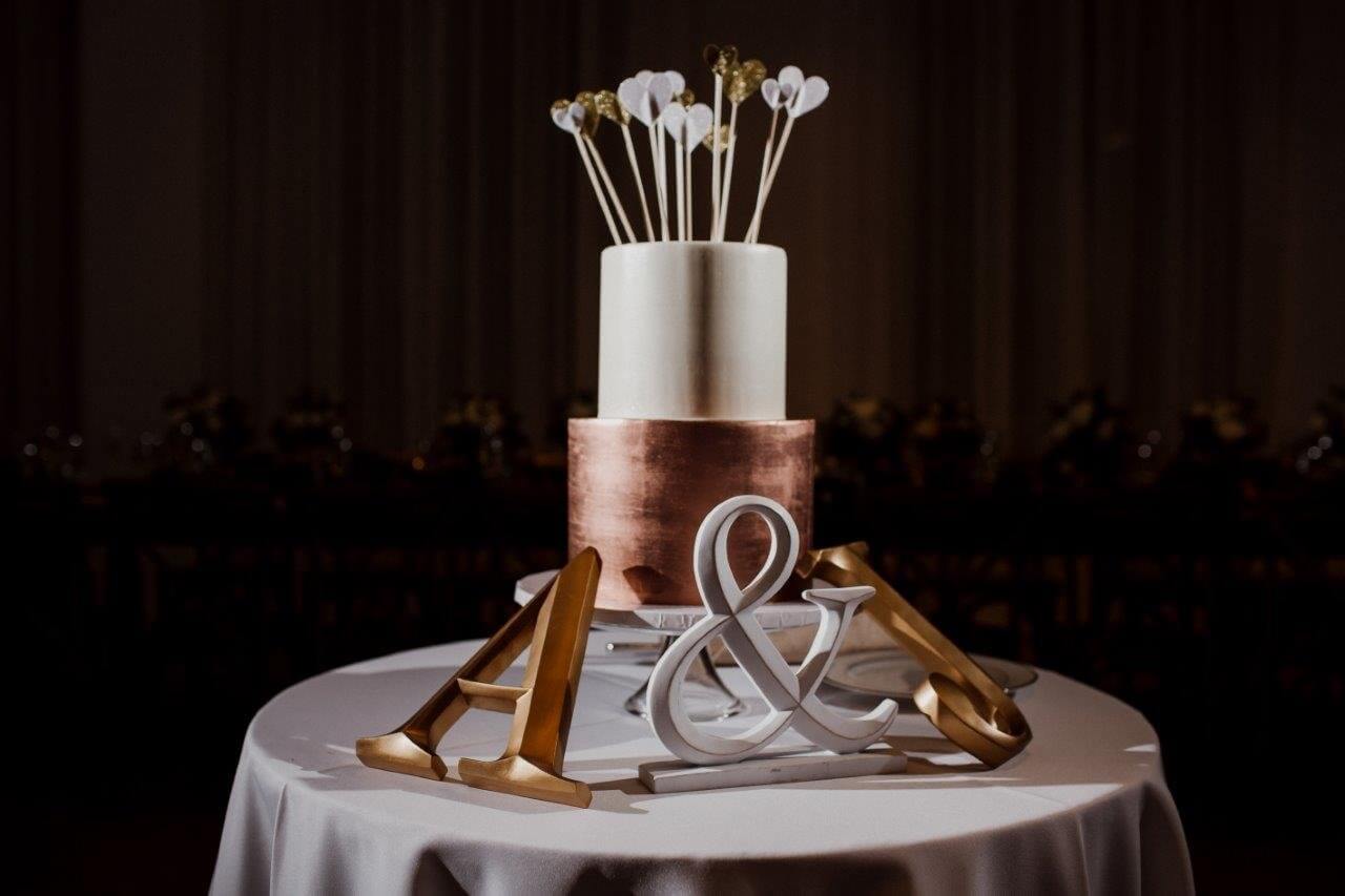 copper and white two tier wedding cake with heart cake topper