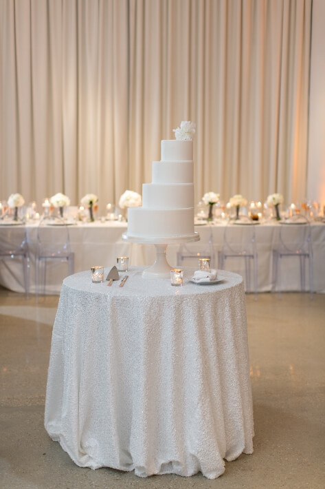 four white tier wedding cake on white sequin table
