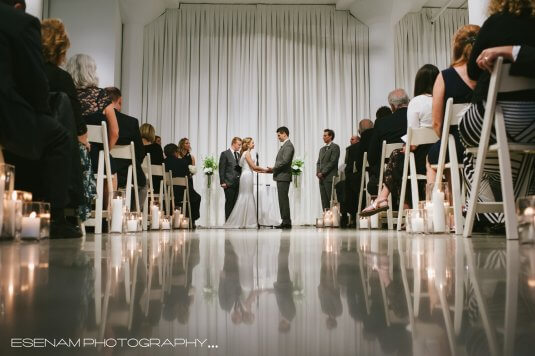bride and groom hold hands at alter in chez at candle lit wedding