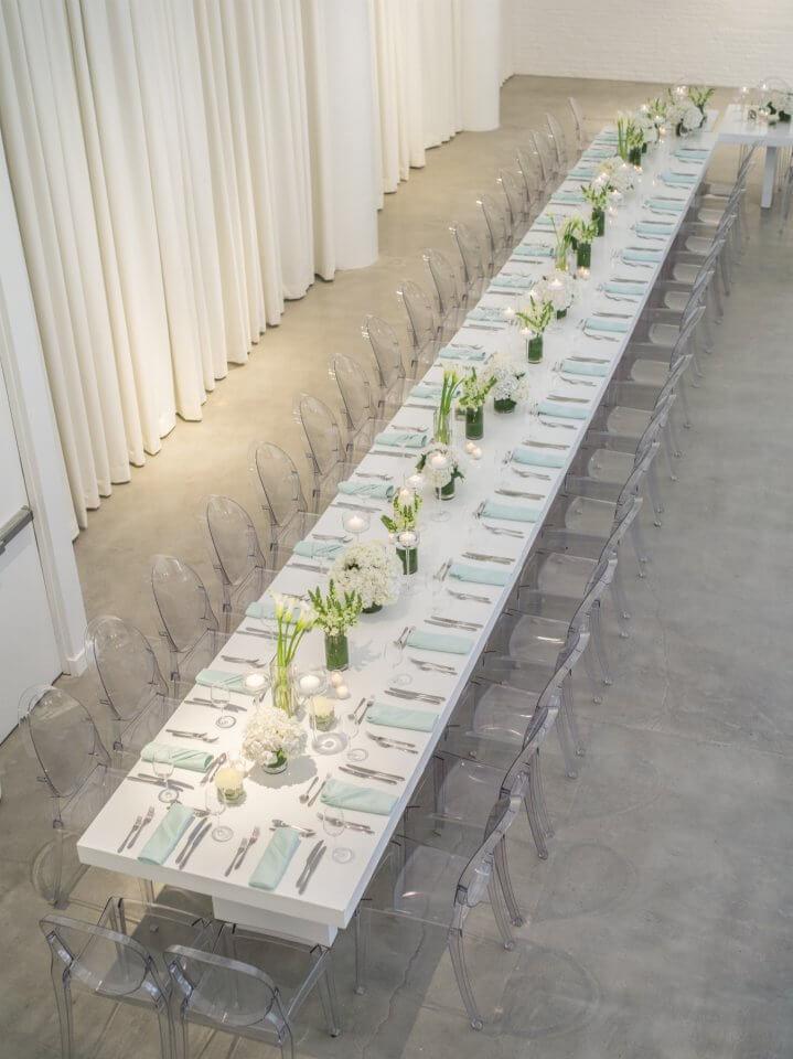 white long rectangular modern table with teal napkins