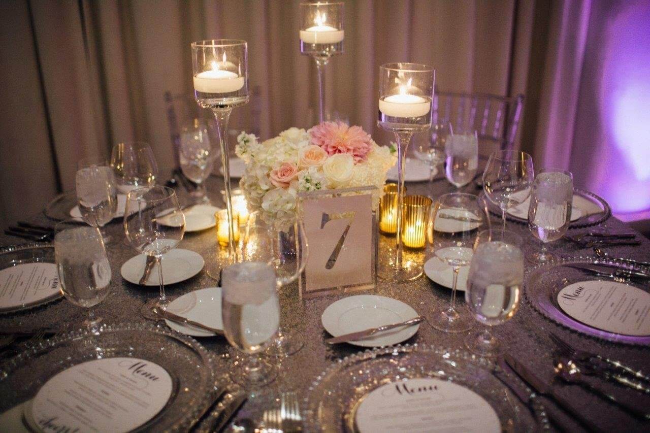 pink and white flowers on silver sequin wedding table with candles