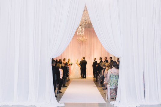 white swagged drape entrance to pink ceremony