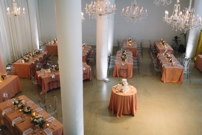 orange themed chicago wedding reception with chandeliers and cake table
