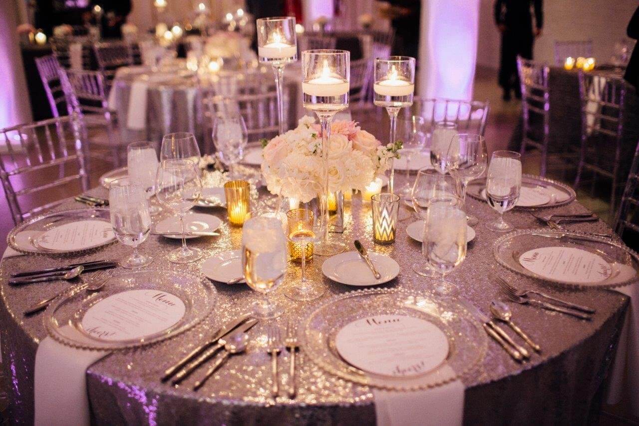 silver sequin round table with lucid plates and candles
