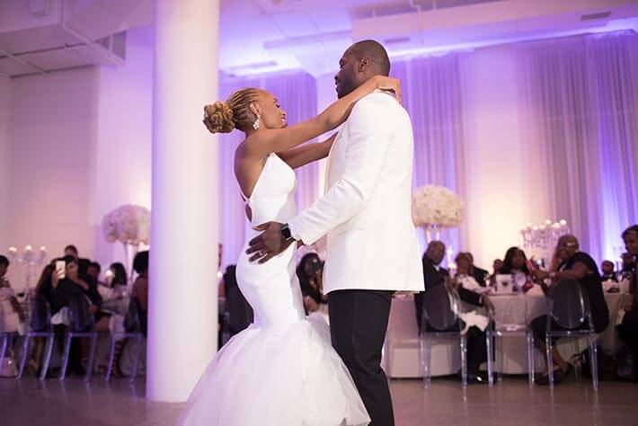bride and groom dance at purple wedding reception