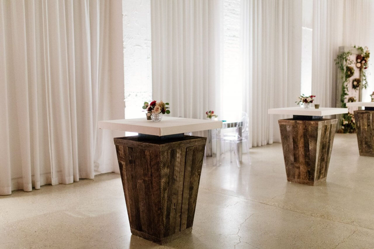 rustic wooden cocktial tables at chez wedding reception