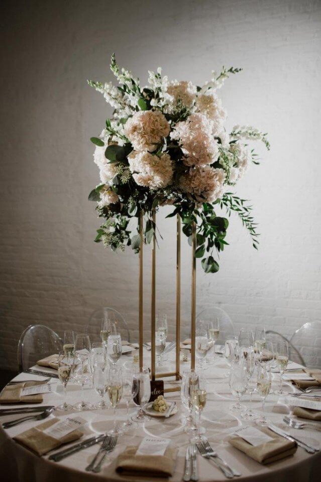 tall whie and green floral centerpiece on white wedding table