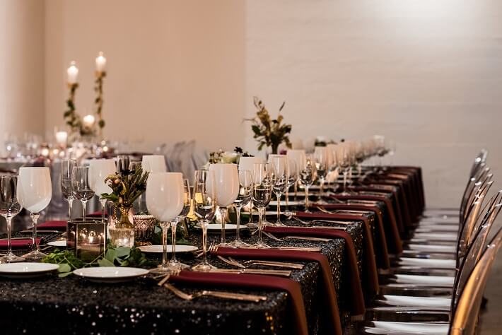 black sequin wedding reception table with burgundy napkins
