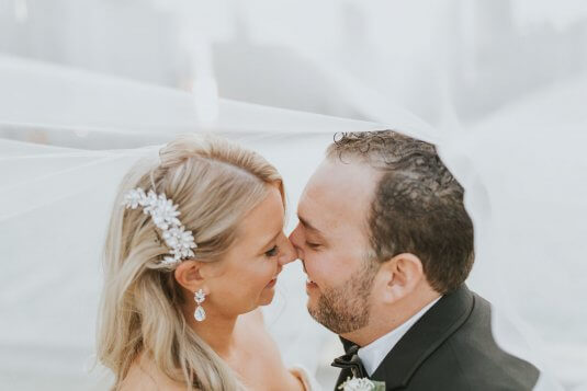 bride and groom underneath brides veil