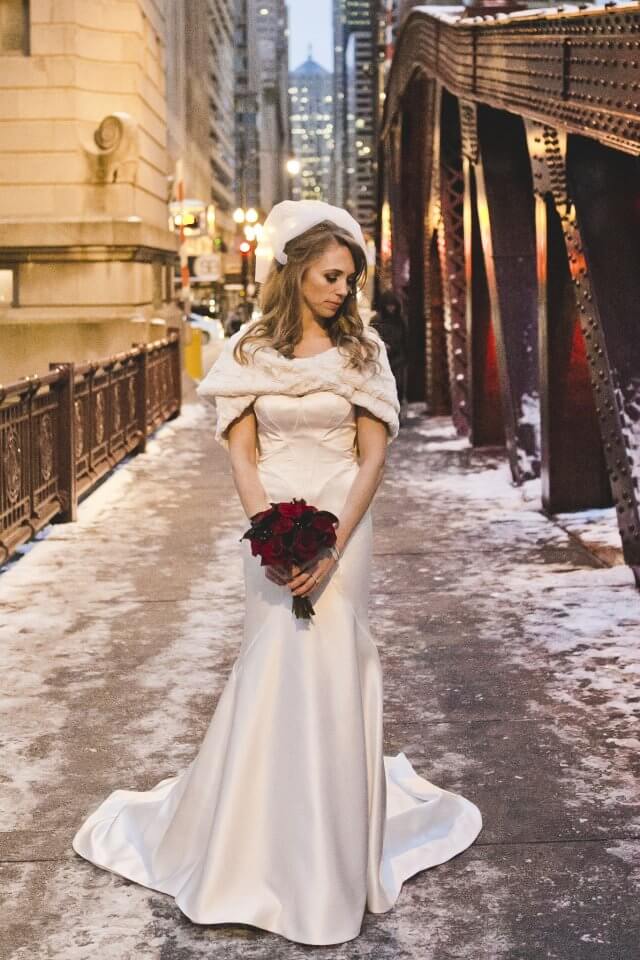 bride wedding portarit holding rose bouquet on chicgao river in snow