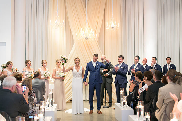 bride and groom walk down candelight aisle
