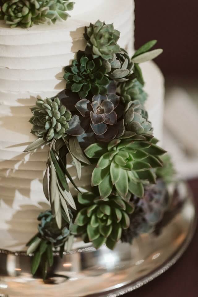 whie wedding cake with green fake flower detail