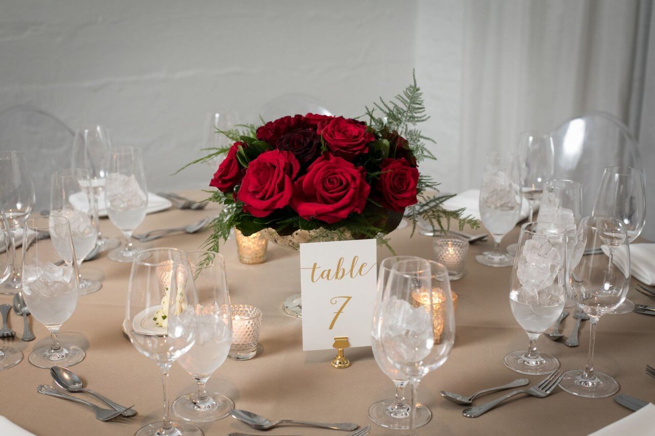 red roses on table with gold table number
