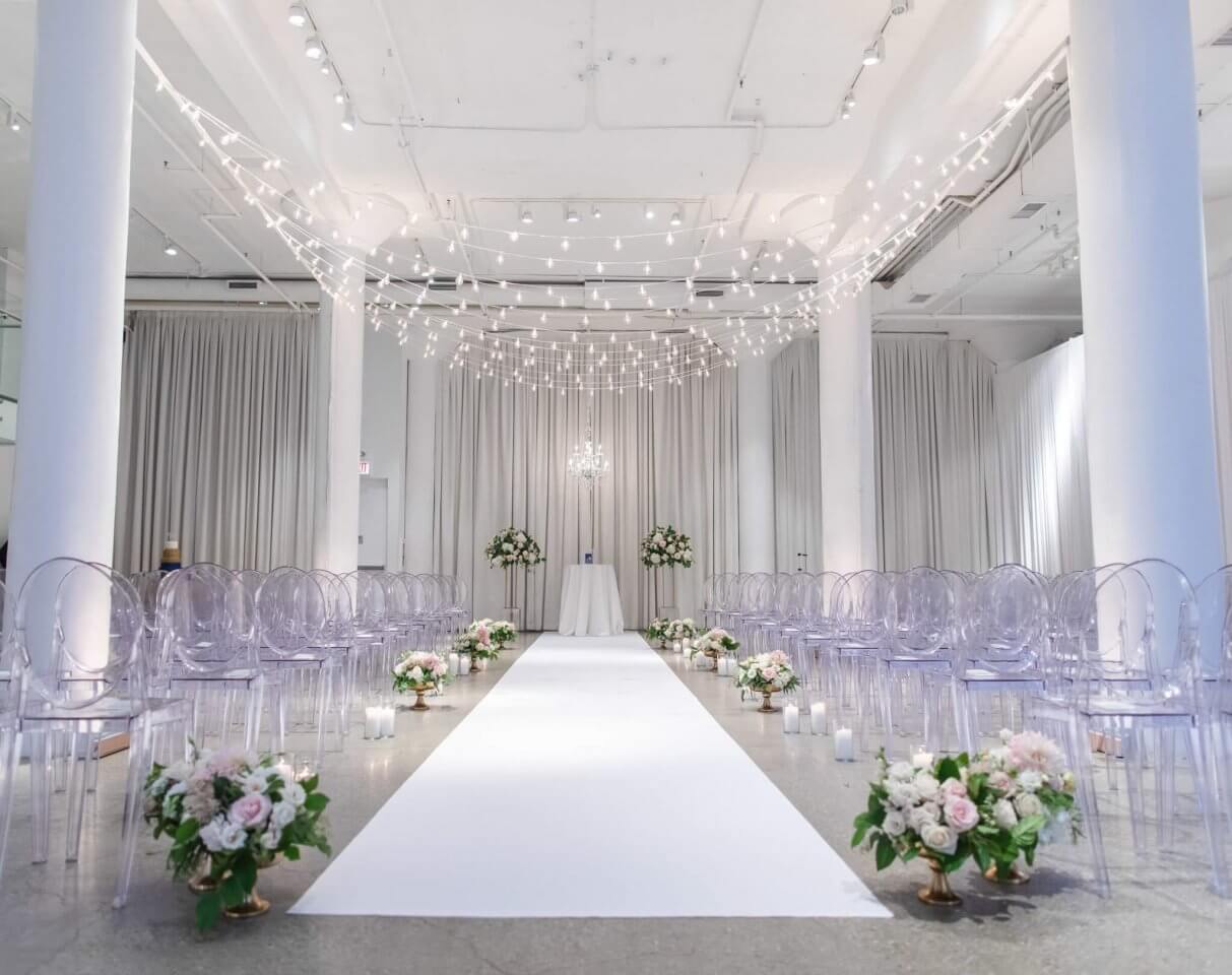wedding aisle with string lights above and floral isle