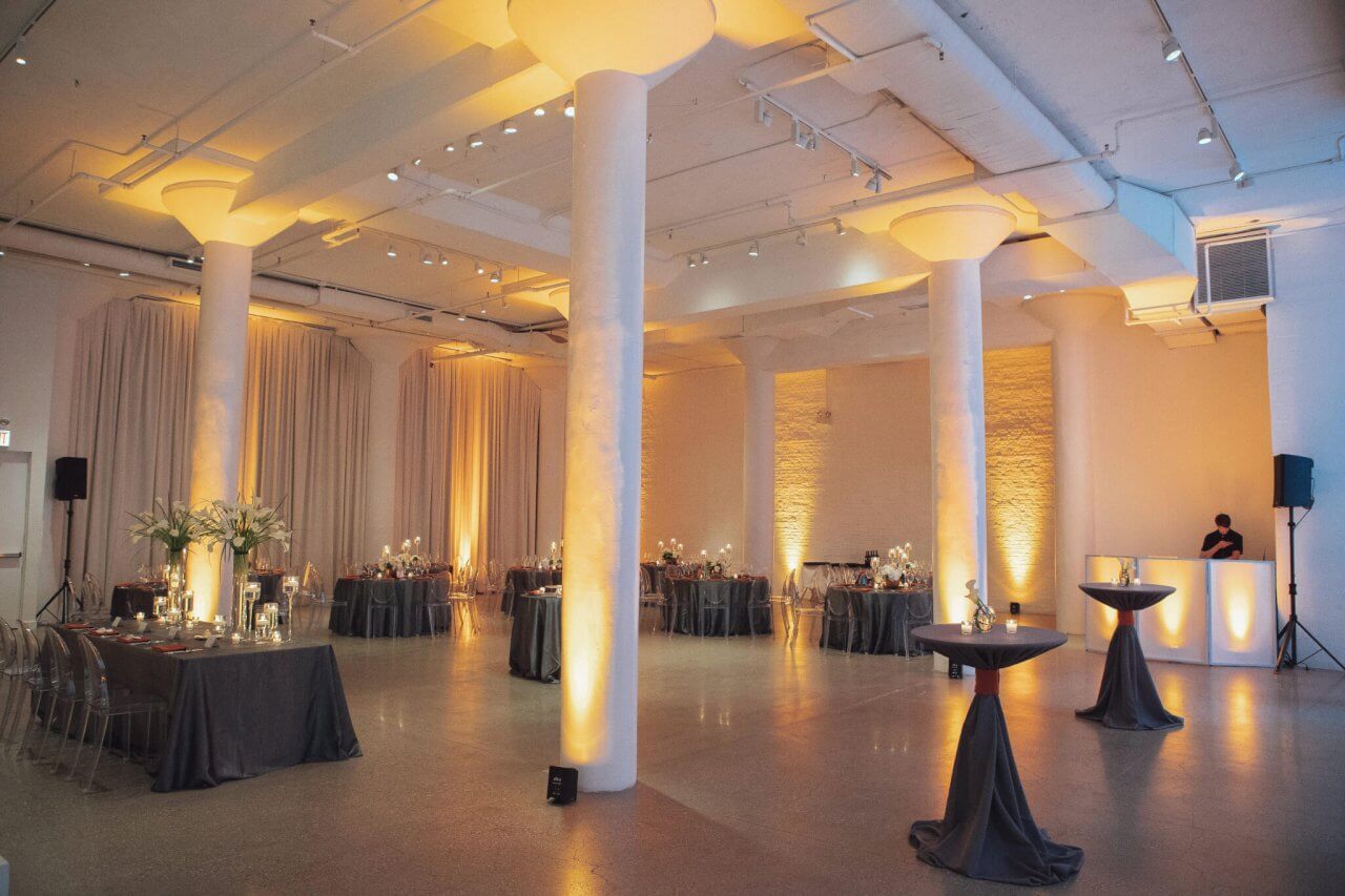 gold uplight wedding reception with grey tables
