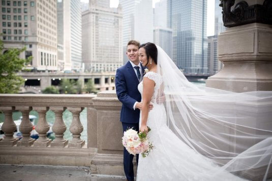 bride and groom in front of chicago river