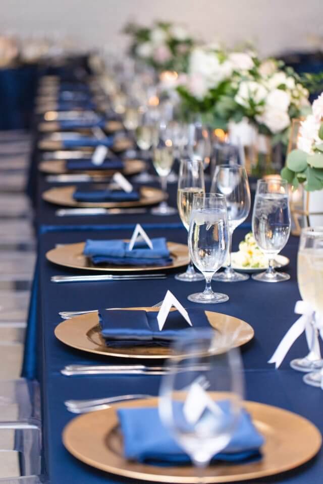 navy and gold table setting on rectangle table