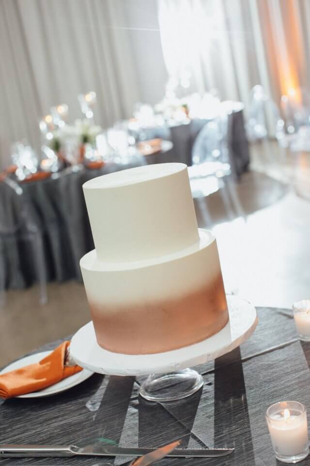 white and copper cake on grey tablecloth