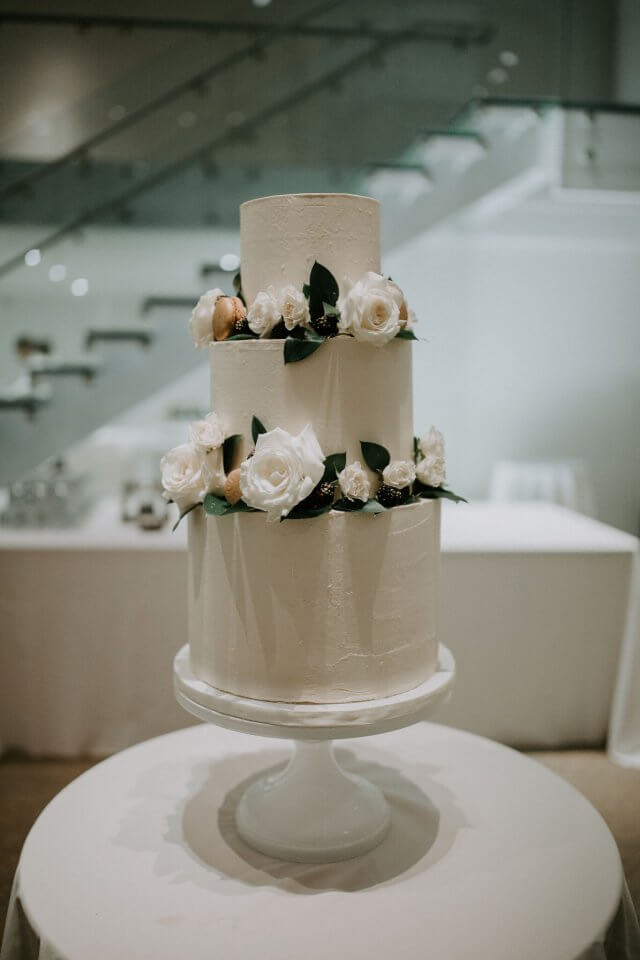 whte wedding cake with macaroons and flowers
