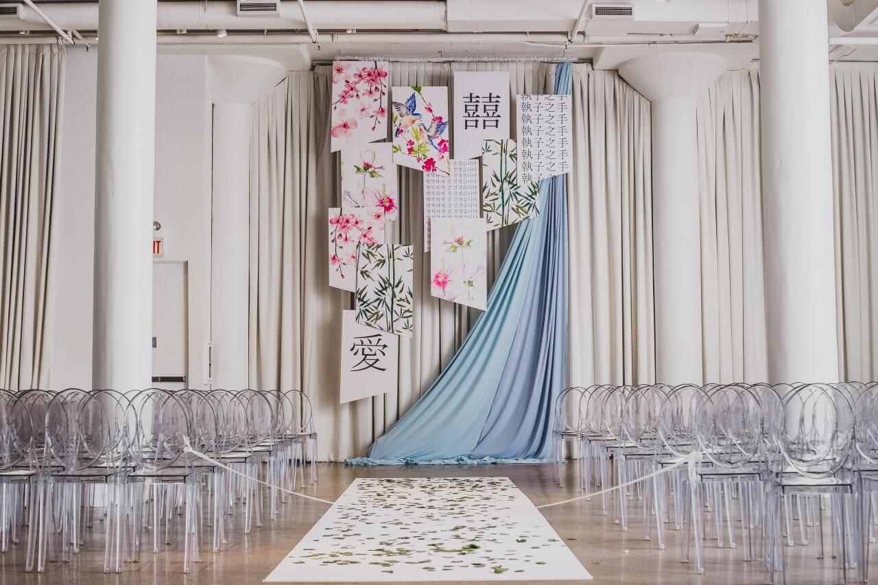 light blue wedding ceremony with hanging korean and chineese art pieces