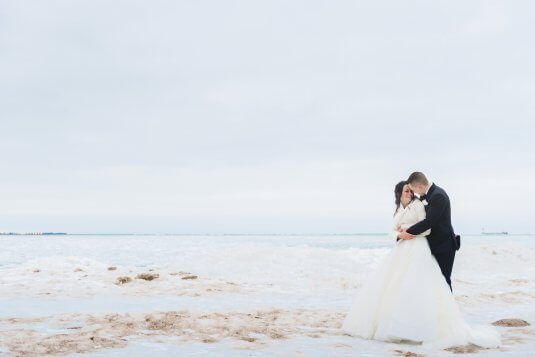 bride and groom hig on chicago beach