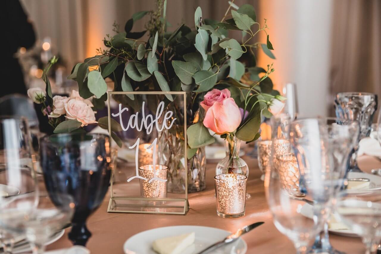 orange wedding table with gold and lucid table numbers