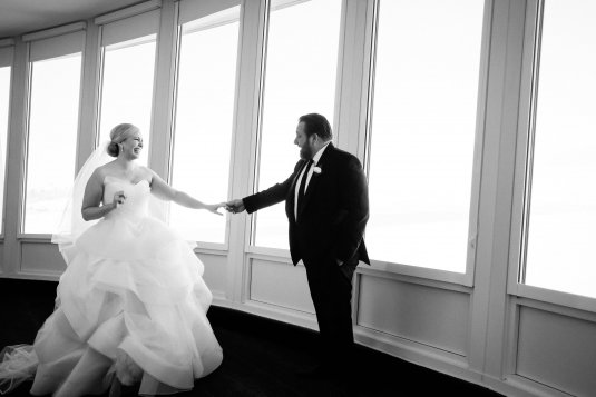black and white photo of the bride and groom holding hands