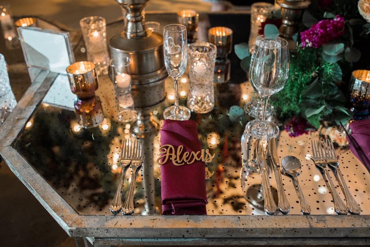 mirrored silver table with burgundy napkin and gold names