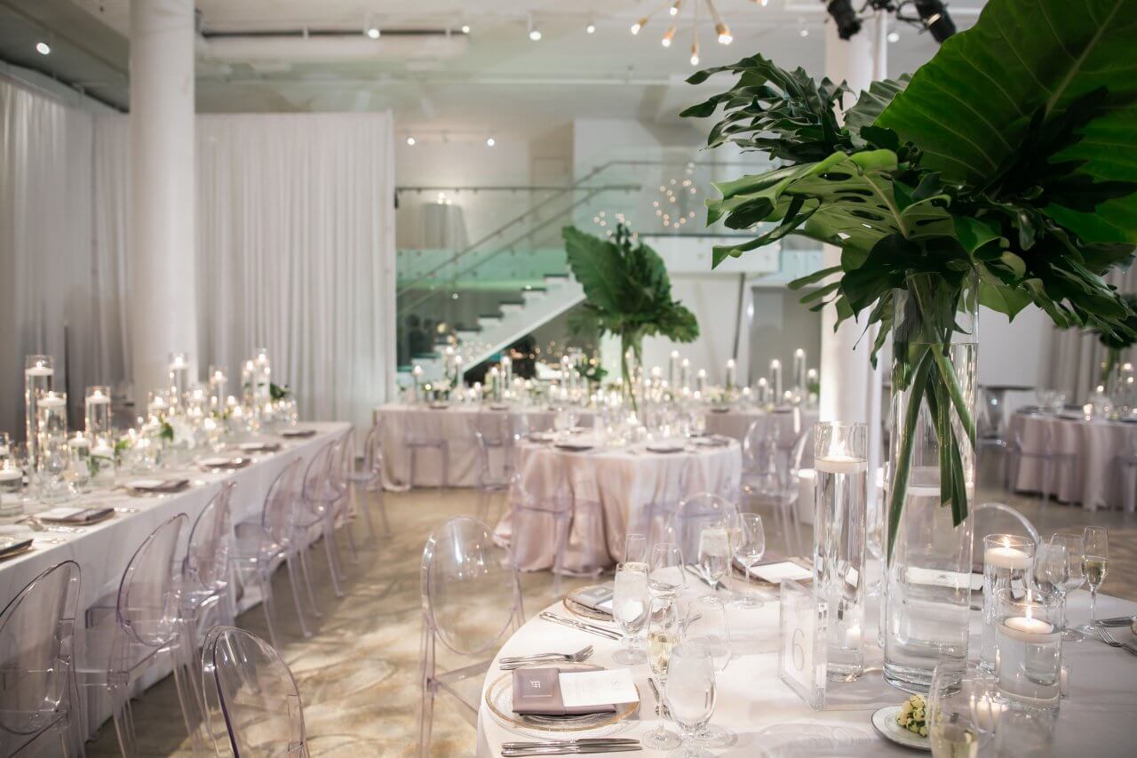 white and green palm leaf wedding reception with many candles