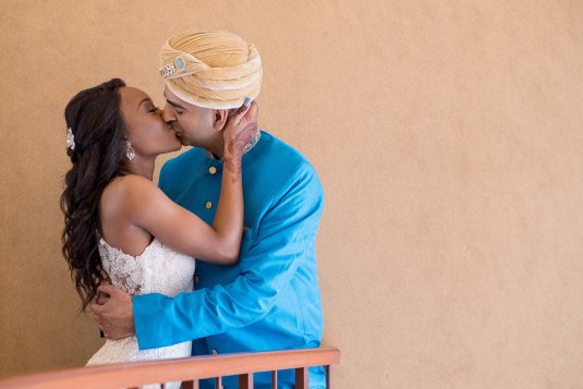 bride and groom dressed in indian clothing kiss