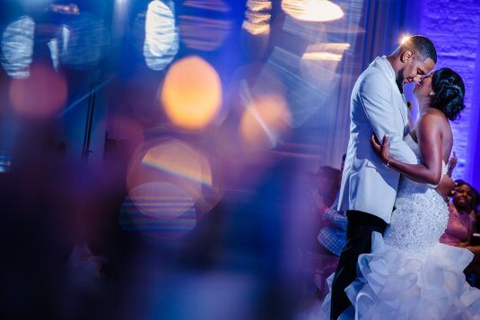 artisitc blurred photo of bride and groom dancing in blue room