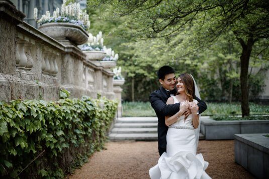 groom hugging groom from behind outside at the art institute