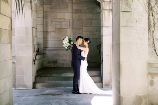 bride and groom hug underneath church arch