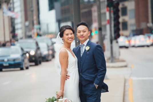 bride and groom stand on median on michigan avenue