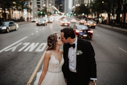 brdie and groom kiss on michigan avenue street